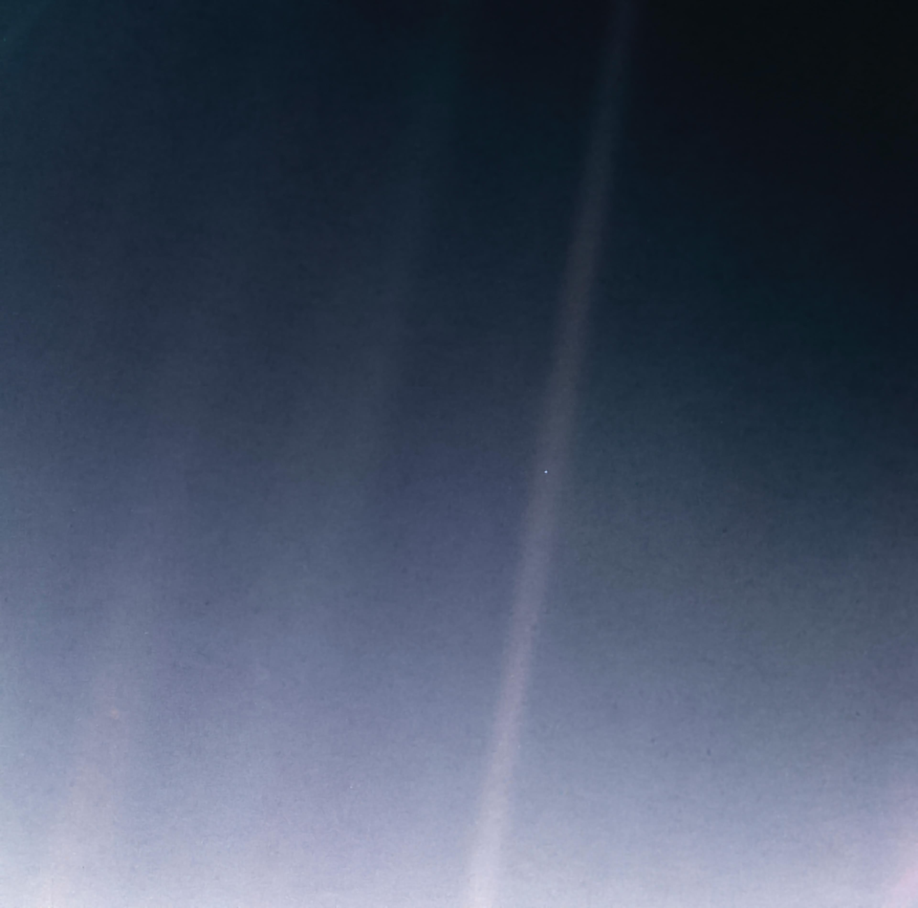 Voyager 1’s Pale Blue Dot: Earth is a tiny speck in a beam of scattered sunlight.